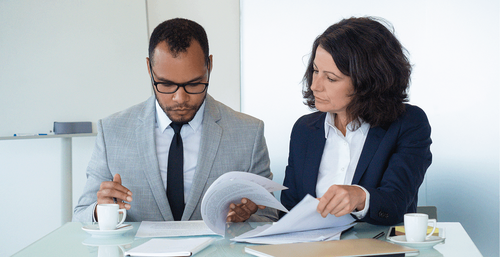 Two care business consultants reviewing regulatory documents together