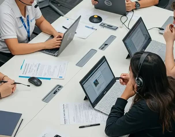 Care professionals working at a table with laptops during a registration consultation