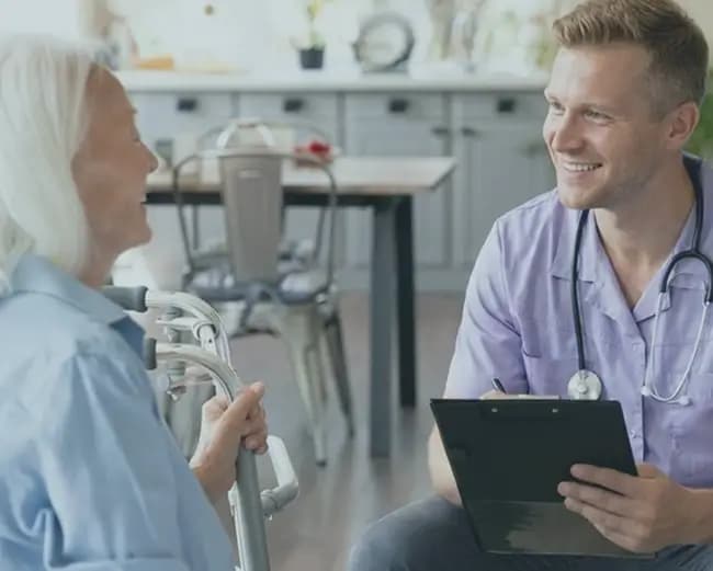 A domiciliary care worker speaking with an older service user at home
