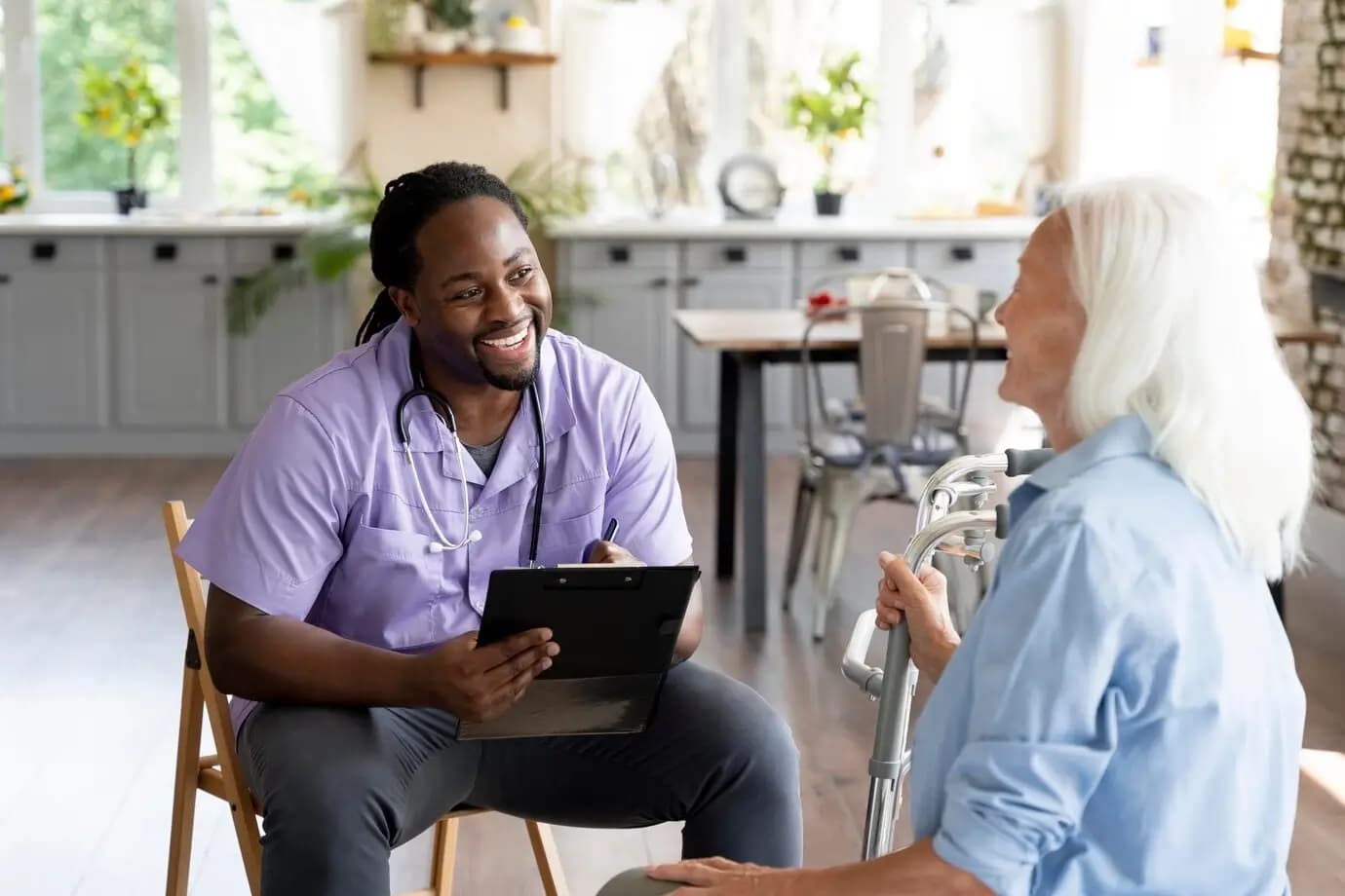 A care professional meeting with an older adult in a home setting