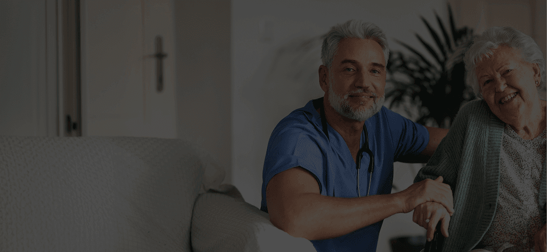 Care professional supporting an older client at home