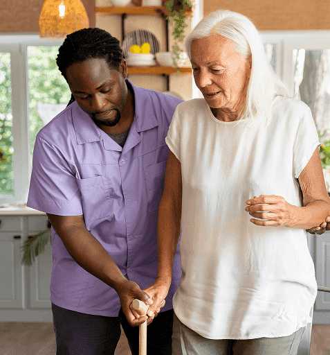 A carer helping a client walk at home