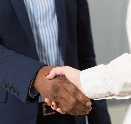 Two professionals shaking hands after a referral meeting