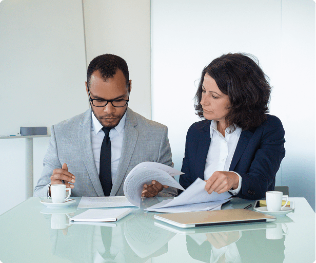Two professionals reviewing tender documents at a table