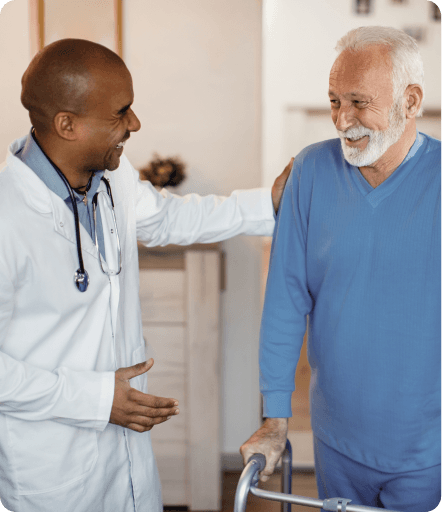 A care worker assisting a person using a walking frame