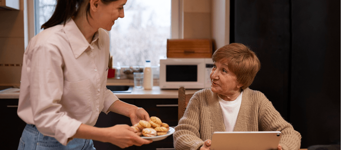 A reablement worker supporting a service user in her kitchen