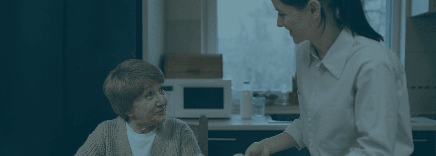 Care worker serving a meal to an elderly resident